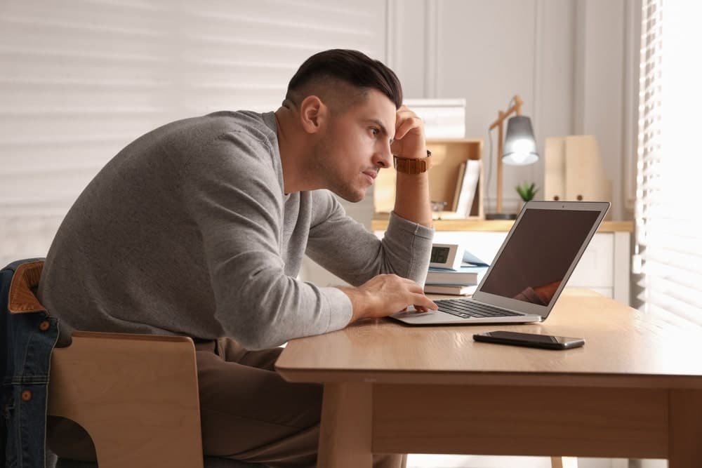 Man Sitting By His Computer With A Bad Posture