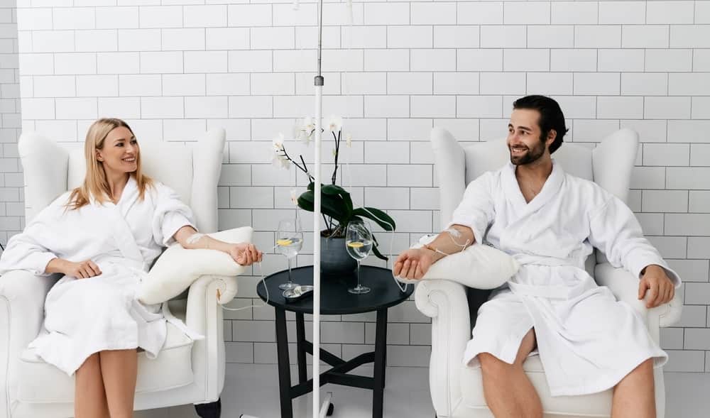 Two People In Bath Robes Hooked Up To IV Bags