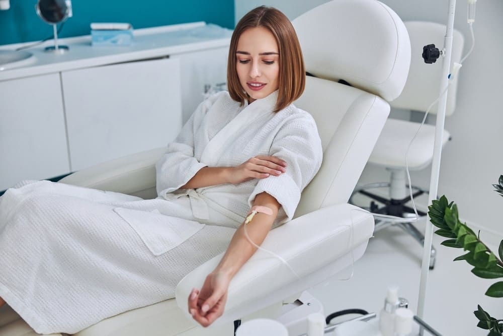 Woman Looking At Her Arm In The IV Therapy Session
