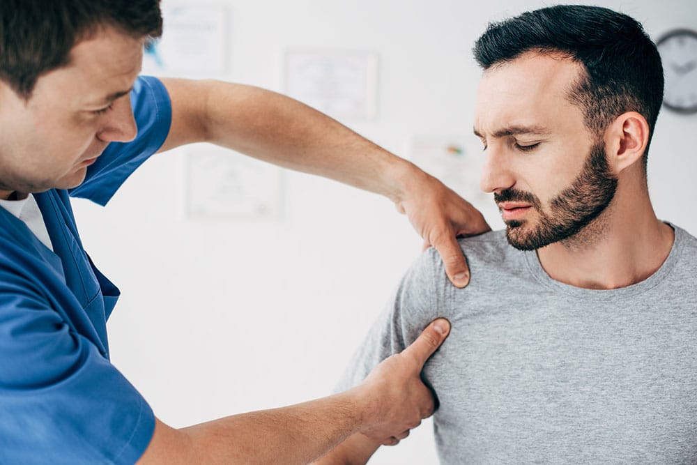 Chiropractor Examining A Patients Shoulder