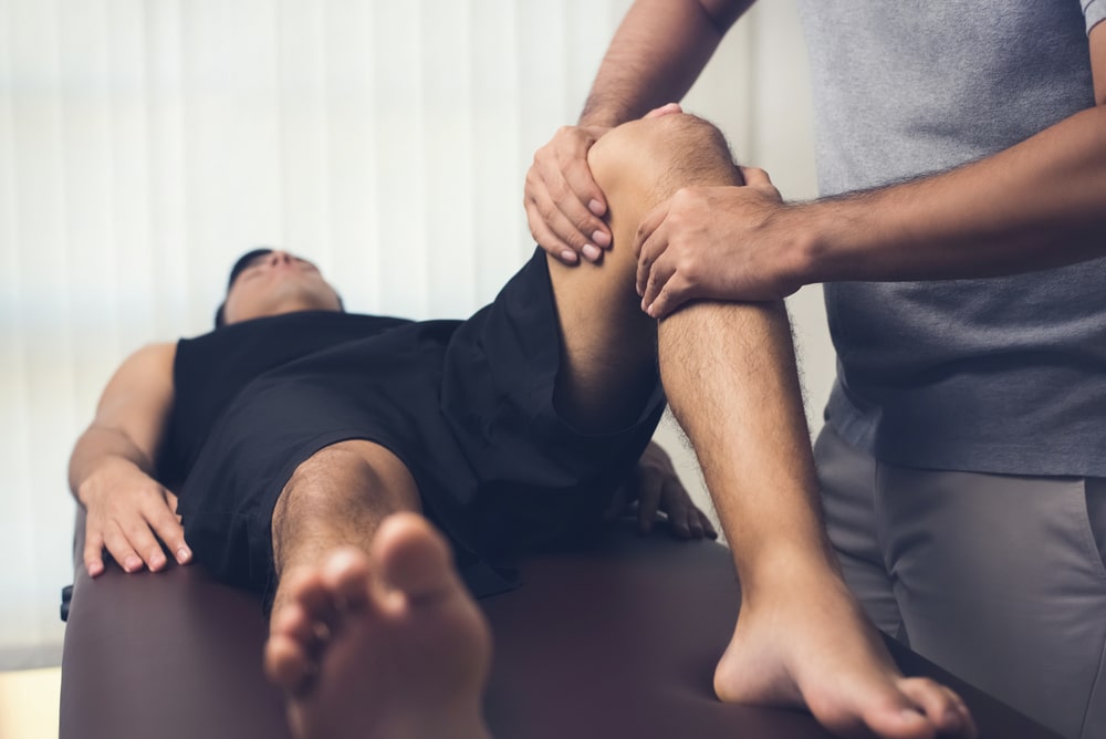 Chiropractor Adjusting A Patients Knee